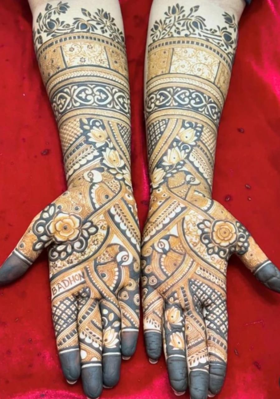 A person showing henna on their hands with a red background