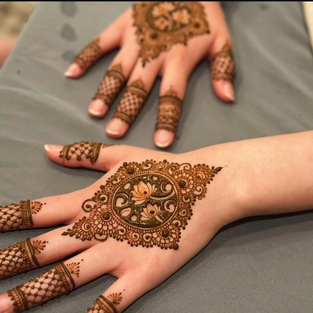 A person showing henna on their hands with a pink background
