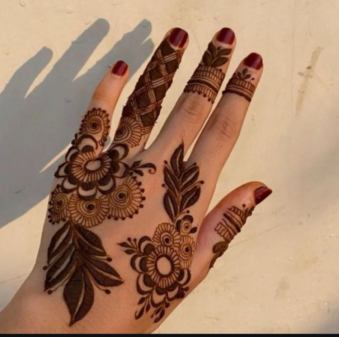 A person showing henna on their hands with a cyan background