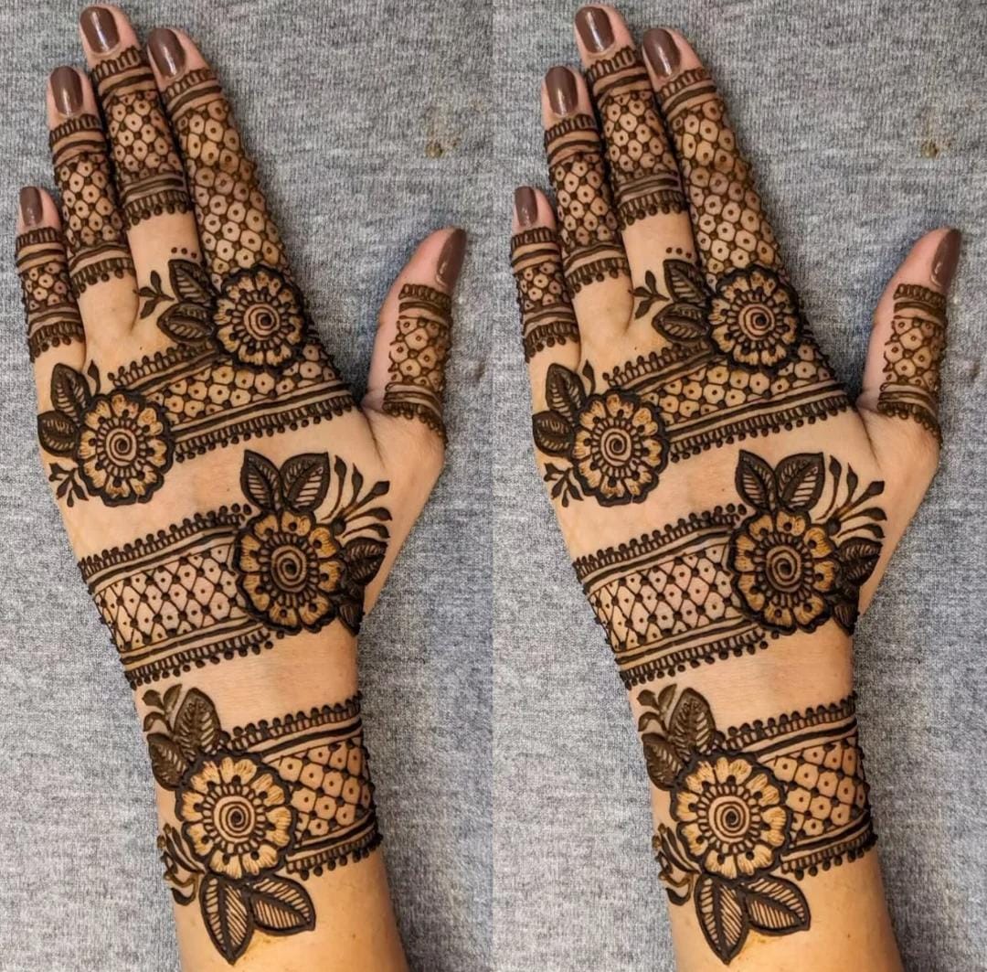 A person showing henna on their hands with a cyan background