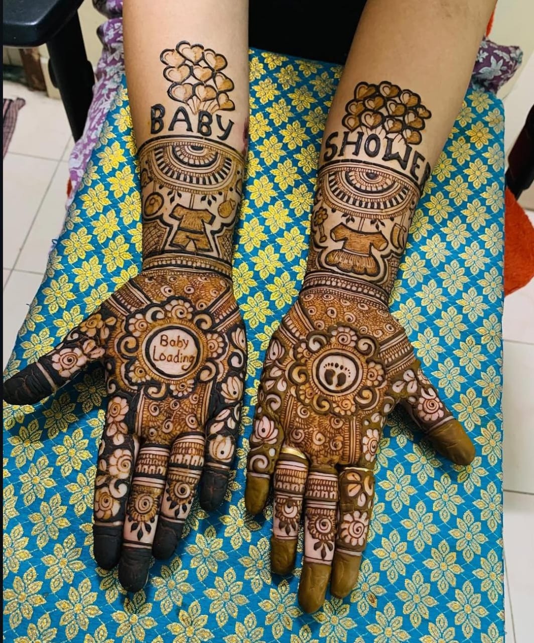 A detailed Baby Shower Mehndi design featuring floral patterns and baby-related symbols
